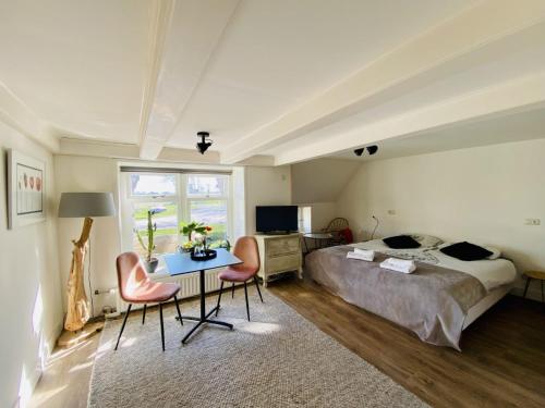 Schlafzimmer mit einem Bett, einem Tisch und Stühlen in der Unterkunft Bed and Breakfast Lauwersstate in Paesens