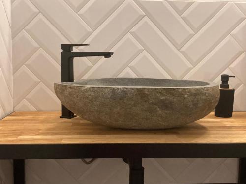 a bathroom with a stone sink on a counter at Chata pod Rogową Apartamenty in Javorina