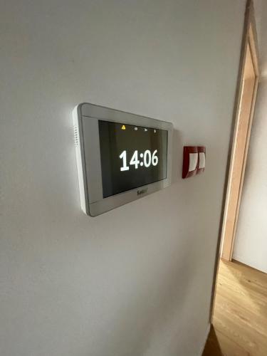 a tv on a wall with a clock on it at Kaszuby, dom kaszubski nad jeziorem Danielowa Dolina in Szymbark