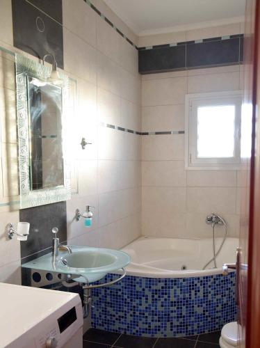 a bathroom with a tub and a sink at Stone Villa in Korinthos