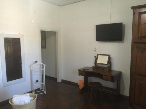 una camera con scrivania e TV appesa a un muro di Villa Mariel - Adults Only Giannella Playa a Orbetello