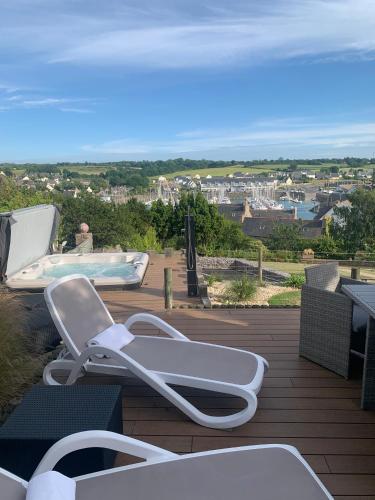 a white lounge chair sitting on a deck with a view at Studio de Charme "Le Coquillage " Jacuzzi privatif in Pléneuf-Val-André