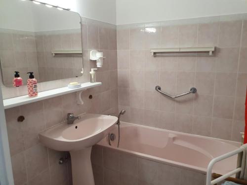 La salle de bains est pourvue d'un lavabo, d'une baignoire et d'un miroir. dans l'établissement Royal Palm Juan les pins -Appartement 53M2 avec terrasse ensolleillée 5e dernier étage 200m de la plage, à Juan-les-Pins
