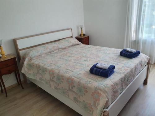 a bedroom with a bed with two blue pillows on it at Royal Palm Juan les pins -Appartement 53M2 avec terrasse ensolleillée 5e dernier étage 200m de la plage in Juan-les-Pins