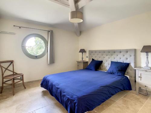 um quarto com uma cama azul e uma janela em **LOVELY APARTMENT IN THE CASTLE OF LA REDORTE** em La Redorte