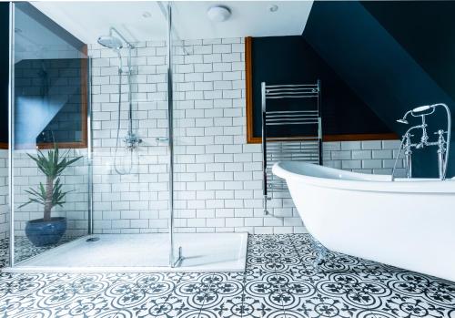 a bathroom with a large tub and a tile floor at The Elm, Abbots Ripton in Abbots Ripton