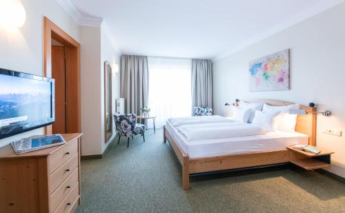 a hotel room with a bed and a television at Die WUNDER s Ferienpension in Pörtschach am Wörthersee