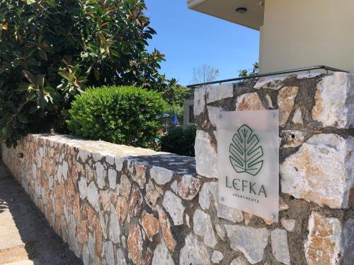 a stone retaining wall with a sign on it at Lefka Apartments in Parigoría