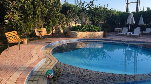 a swimming pool in a backyard with chairs and tables at Lefka Apartments in Parigoría