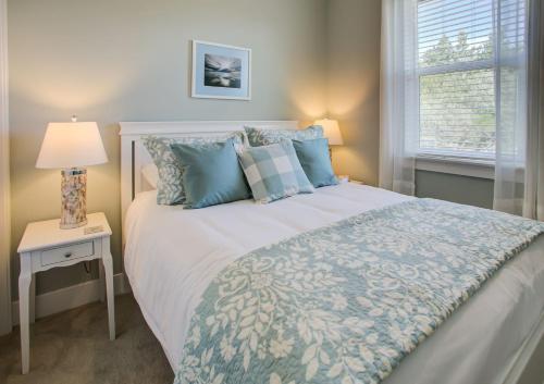 a bedroom with a bed and a lamp and a window at Sand Castle Cottage - Oyhut Bay Seaside Village in Ocean Shores