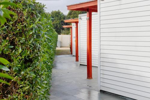 a walkway between two white buildings with a red roof at Cabañas Rio Rapel in Rapel