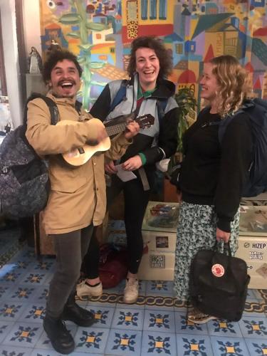 a group of three people standing in a store playing a guitar at Fatima Hostel Bogotá in Bogotá