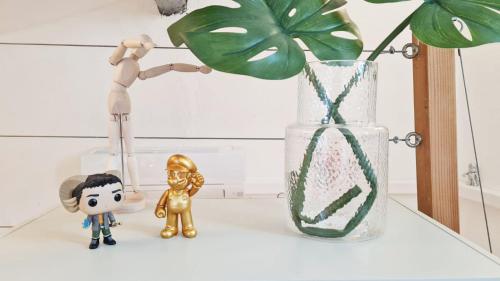 deux figurines de jouets assises sur une table à côté d'un vase dans l'établissement GregBnb - T2 CLIMATISÉ Mezzanine - Atypique - Centre Ancien - 5e etage sans ascenseur, à Toulon