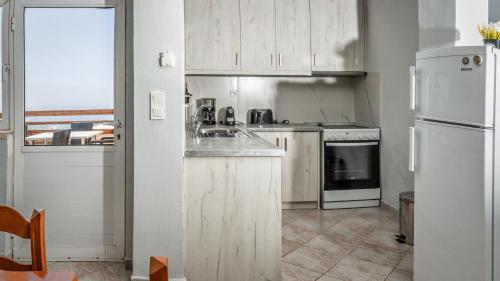 a kitchen with white cabinets and a white refrigerator at President's House in Kerames