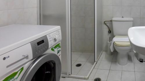 a washing machine in a bathroom with a toilet at President's House in Kerames