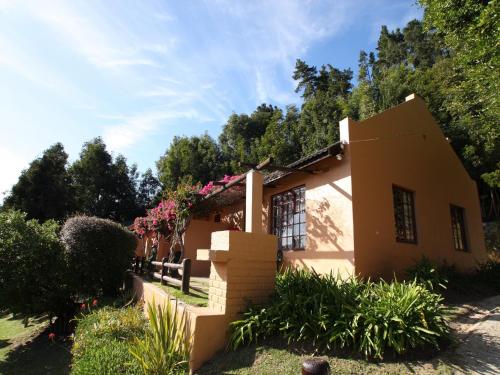 a house with flowers on the side of it at Gooderson Knysna Chalets in Knysna