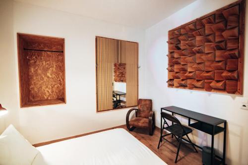 a bedroom with a bed and a desk and a mirror at LX Hostel in Lisbon