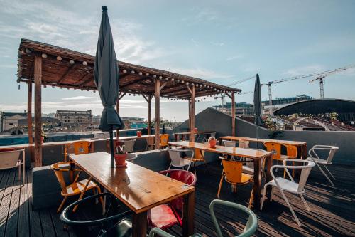 a patio with tables and chairs and an umbrella at LX Hostel in Lisbon