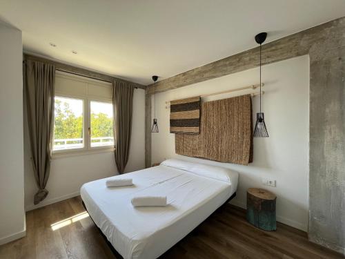 a bedroom with a large white bed and a window at Apartamento Vela Cambrils Playa in Cambrils