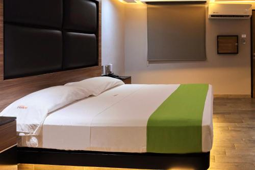 1 dormitorio con 1 cama con manta verde y blanca en Auto-Hotel Playa Linda en Veracruz