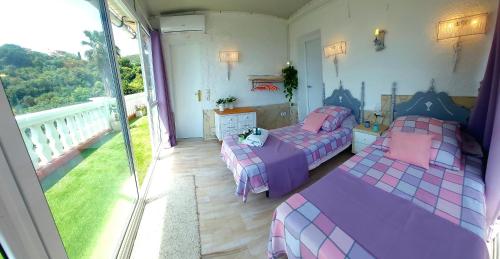 Dos camas en una habitación con balcón. en Villa Mar i Cel con jacuzzi, en Tossa de Mar