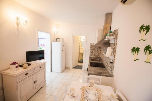 a living room with a refrigerator and a television at Beach Holiday Home Laura in Mimice