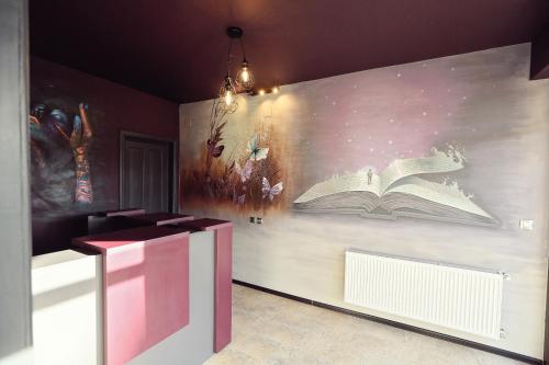 una habitación con una pared con un mural de un libro en Dezire Guesthouse, en Baile 1 Mai