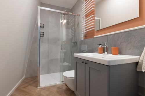 a bathroom with a toilet and a sink and a shower at Glow Apartments, Aparthotel Kołłątaja - Wrzeszcz in Gdańsk