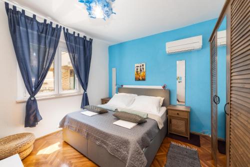 a bedroom with a bed with a blue wall at Family in Gradac