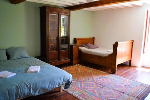 - une chambre avec 2 lits, une fenêtre et un tapis dans l'établissement Maison typique - Très grand jardin - 7km de la mer, à Fontaine-Henry