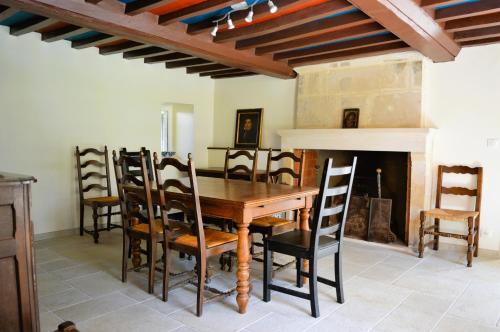 une salle à manger avec une table et des chaises et une cheminée dans l'établissement Maison typique - Très grand jardin - 7km de la mer, à Fontaine-Henry