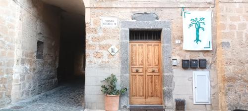 a building with a wooden door and a potted plant at La casa di Agnese in Orvieto