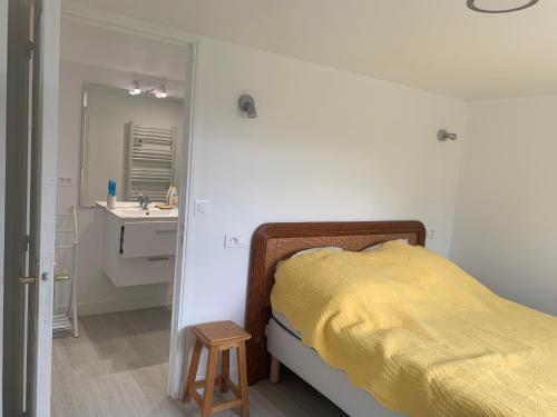 a bedroom with a yellow bed and a sink at suite junior OMAHA BEACH in Flers