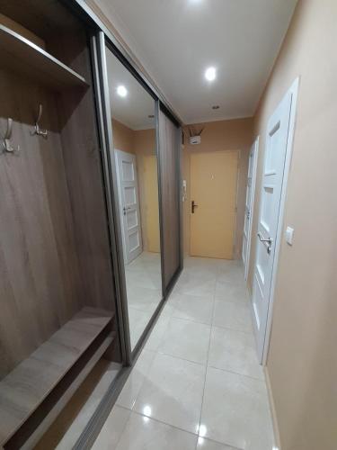 a hallway with glass doors and a tiled floor at Beautiful apartment in the city center in Spišská Nová Ves