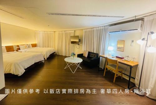 a hotel room with two beds and a desk at River Hotel in Chiayi City