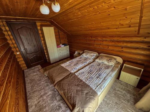 a bedroom with a bed in a log cabin at GorodOk in Migovo