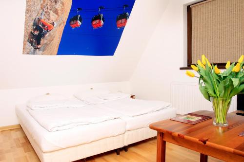 a bed in a room with a table and a painting at Podlesice 38 in Kroczyce