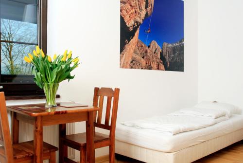 a room with a table with a vase of flowers on a table with at Podlesice 38 in Kroczyce