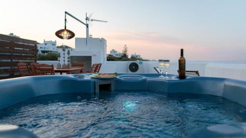 niebieski basen ze stołem i butelką wina w obiekcie white house apollon naxos w mieście Apollon