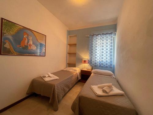 ヴァッレドーリアにあるVilla Monte Assariのベッド2台が備わる客室で、壁には絵画が飾られています。