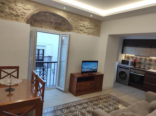 Il comprend un salon avec une télévision et une cuisine. dans l'établissement ISAMAR Apartamentos, à Vejer de la Frontera