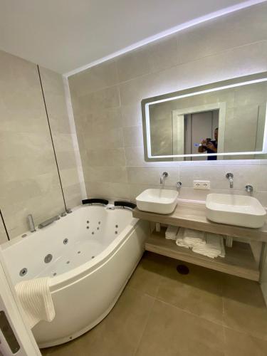a bathroom with two sinks and a tub and a mirror at Loft Deluxe Raquel in Conil de la Frontera