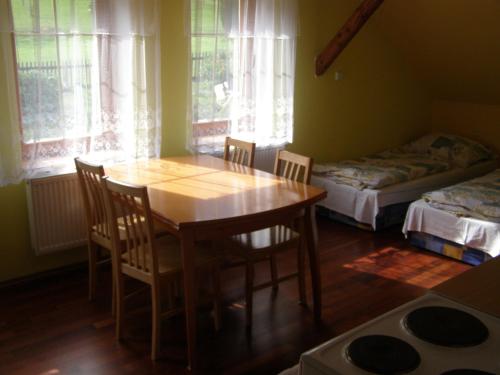 a dining room with a table and chairs and a bed at Ubytování U Kramárů in Josefŭv Dŭl