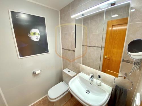 a bathroom with a toilet and a sink and a mirror at Encantador alojamiento en Altea Hills in Altea