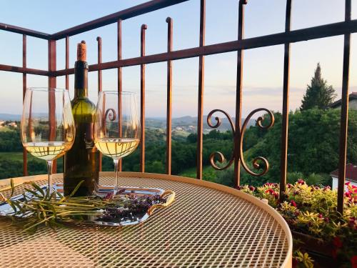 a table with two glasses and a bottle of wine at Enam Room in Kojsko