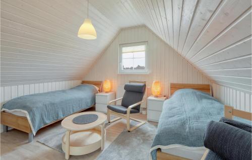 a attic bedroom with two beds and a chair at 2 Bedroom Nice Home In Zerpenschleuse in Zerpenschleuse