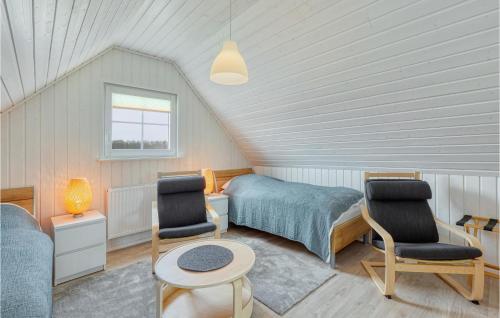 a bedroom with a bed and two chairs and a table at 2 Bedroom Nice Home In Zerpenschleuse in Zerpenschleuse