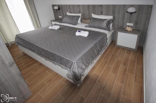 um quarto com uma cama grande e piso em madeira em Apartmani Aleksic em Trebinje