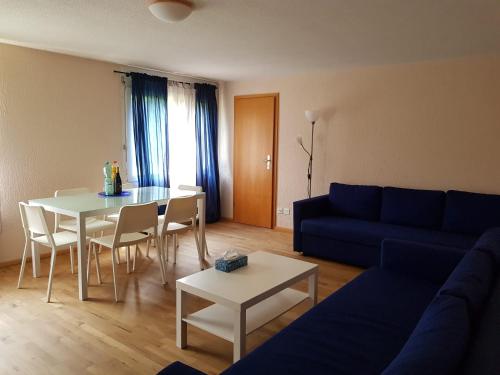 sala de estar con sofá azul y mesa en 2 Rooms cosy Apartment near Liechtenstein, en Haag