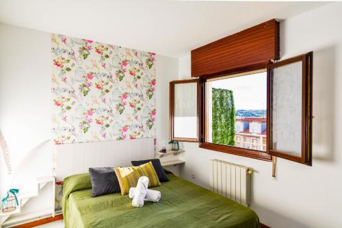 sypialnia z zielonym łóżkiem i oknem w obiekcie Apartamento con vistas al mar-Ola del atardecer w mieście Mogro